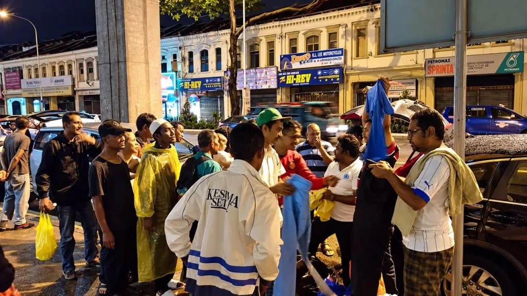 LIFE Malaysia volunteers handing out food on a Kuala Lumpur street at night, 2015