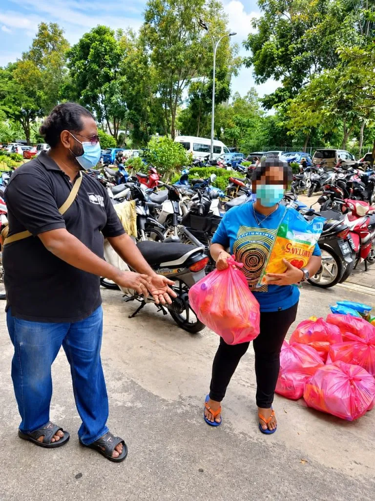 A volunteer hands bags of food aid to a resident during the 2021 White Flag campaign
