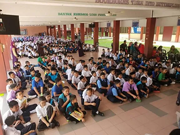 Pupils seated in a school hall for the Back2School programme at SK Seri Suria