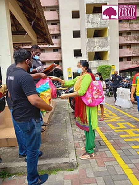 A volunteer delivers food supplies to a resident during the White Flag campaign, 2021